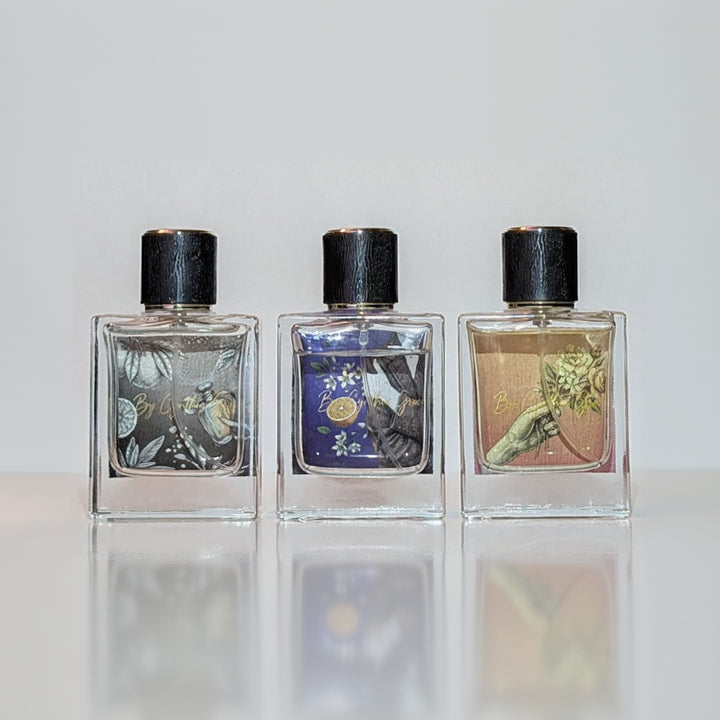Three perfume bottles with decorative labels on a white background